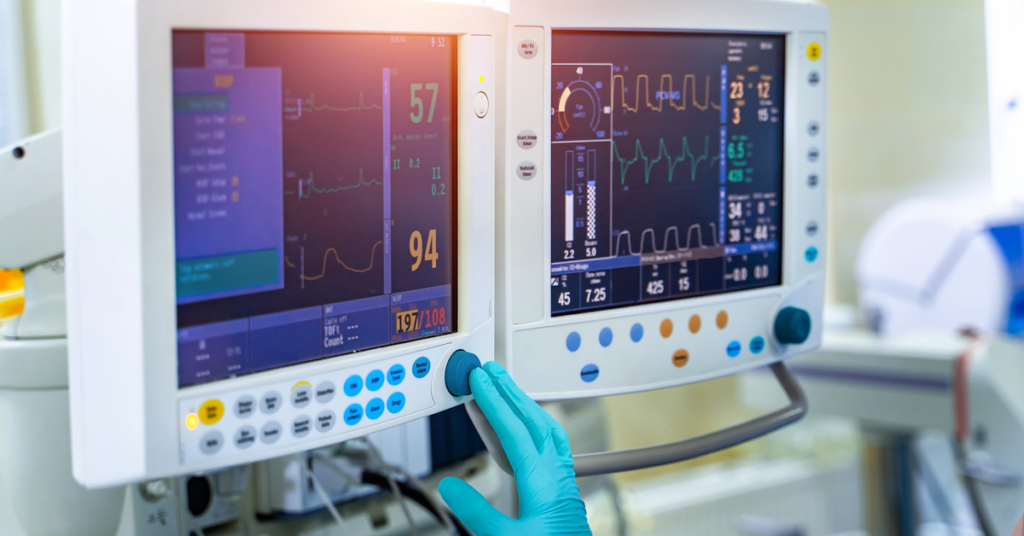 A MedTech environment featuring a worker interacting with two medical devices, providing critical health data and monitoring vital signs.