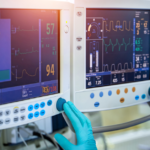 A MedTech environment featuring a worker interacting with two medical devices, providing critical health data and monitoring vital signs.