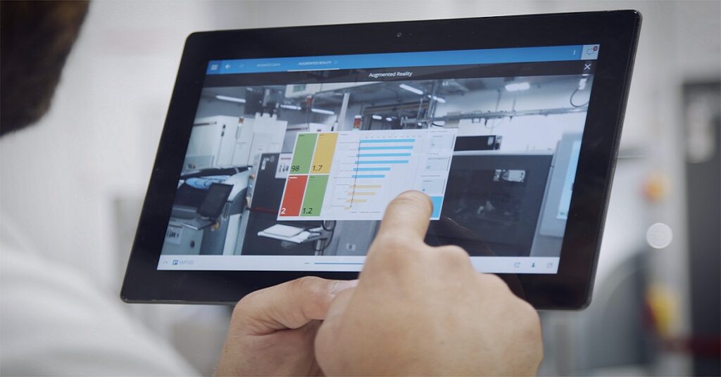 Worker touching tablet´s screen, which has Critical Manufacturing´s MES open