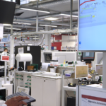 Man in a lab setting engages with a remote control, showcasing MES advancements that surpass traditional traceability.