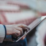 Young man using digital tablet on the empty football stadium