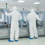 Manufacturing Facility Team of Scientist Wearing Sterile Protective Coverall Set's up / Programs Modern Industrial 3D Printer, High Precision Manufacture of Semiconductors under Process