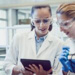 Two Young Female Scientists Looking at the PC tablet