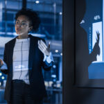 A woman in a business suit confidently presents to an audience, aligning her message with CEO priorities.