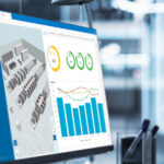 A monitor displaying a detailed and complex graph, suggesting a meeting or presentation involving data analysis and the concept of digital twin
