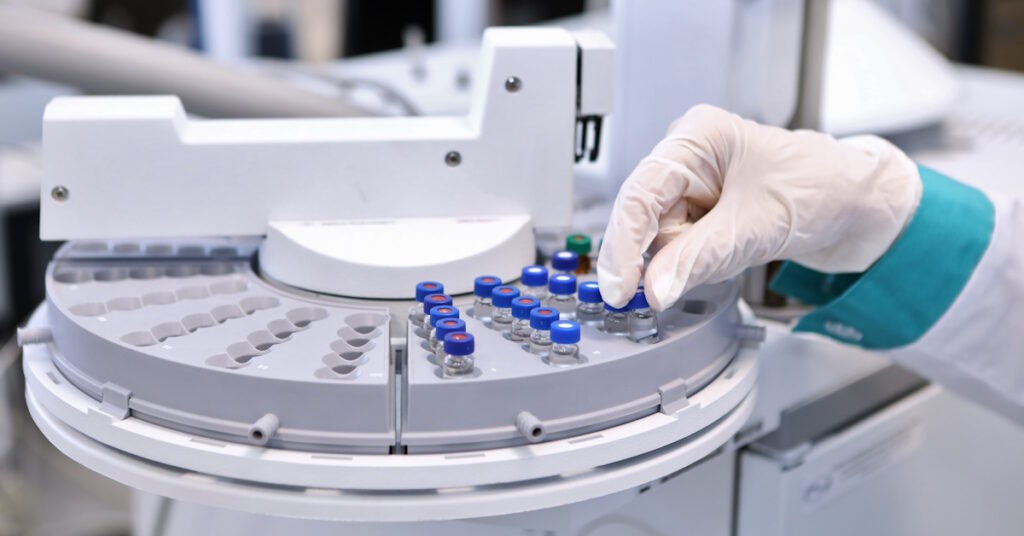 Quality Control Laboratory medicine. Chromatograph operation. A woman makes an analysis on a gas chromatograph. Development of a new vaccine against the covid-19 virus