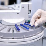 Quality Control Laboratory medicine. Chromatograph operation. A woman makes an analysis on a gas chromatograph. Development of a new vaccine against the covid-19 virus